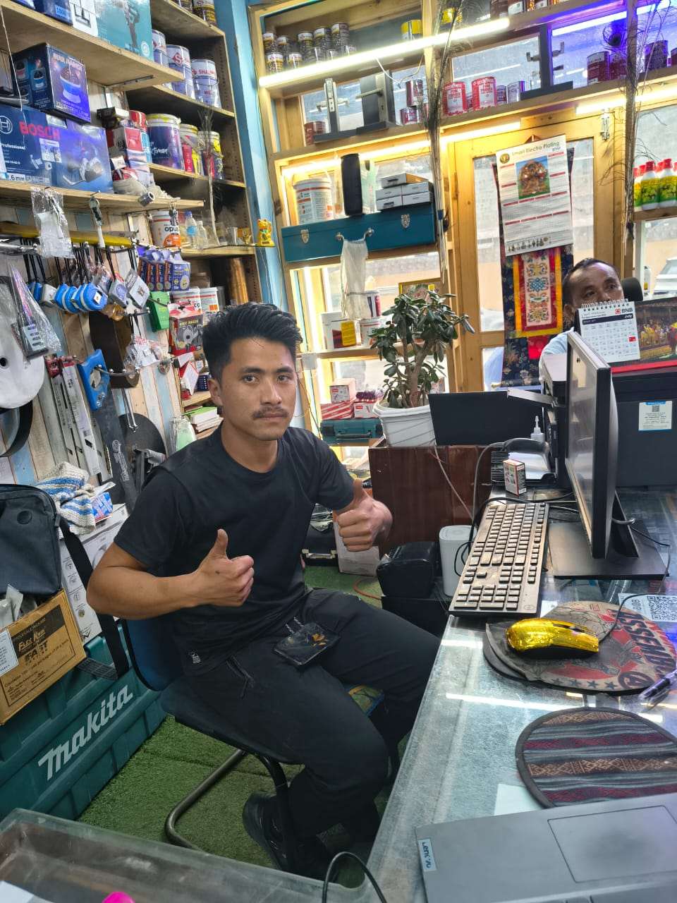 Kezang Enterprise staff giving a thumbs-up at the aBitPOS billing terminal after go-live
