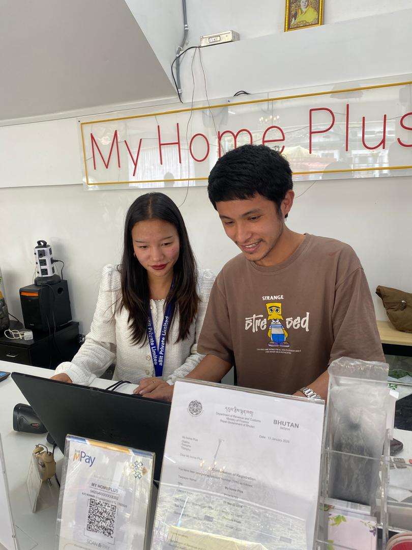 My Home Plus team on aBitPOS at the counter beneath the store signboard, with GST registration and mBoB QR on display